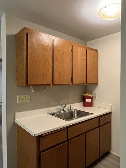 A kitchen with wooden cabinets and a white countertop.